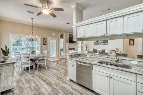 a kitchen with white cabinets and a dining room at Sandy's Seacrest in Inlet Beach
