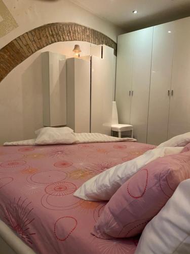 1 dormitorio con 1 cama grande con manta rosa en IL VICOLO, en Comacchio