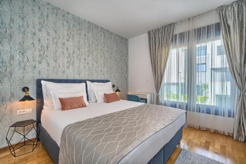een slaapkamer met een bed en een groot raam bij www VillaCelestial com in Split