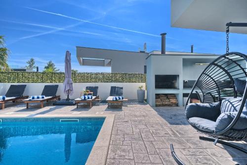 um pátio com piscina e cadeiras e uma casa em Villa Celestial em Split