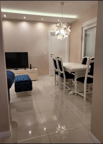 a dining room with a white table and chairs at Apartman Cookie Kolačić blizu aerodroma Nikola Tesla in Dobanovci
