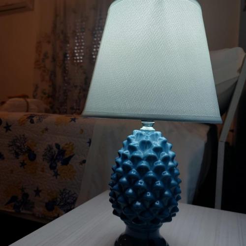 a blue glass lamp sitting on top of a table at Marea affittacamere in Porto Empedocle