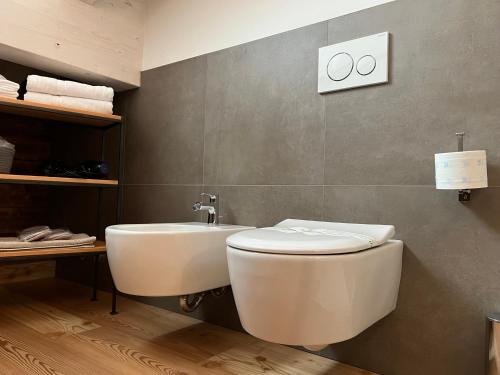 a bathroom with a toilet and a sink at Camelot Luxury Houses Horses in Pellizzano