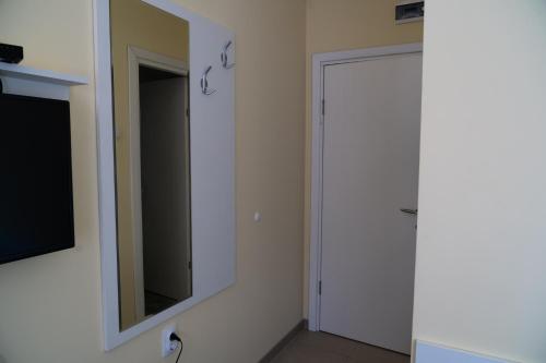 a bathroom with a mirror and a door at Studio Apartments Maksimović in Niš