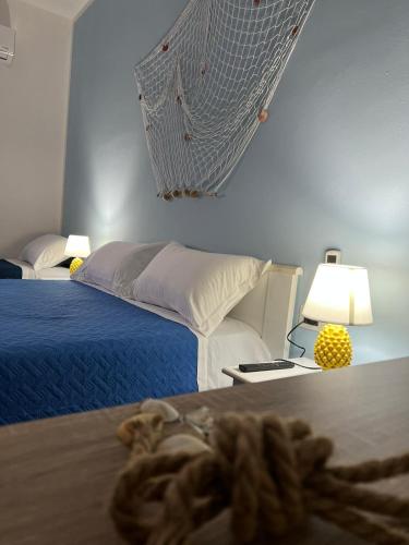 a bedroom with a bed and a table with a lamp at Marea affittacamere in Porto Empedocle