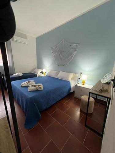 a bedroom with two beds with blue sheets at Marea affittacamere in Porto Empedocle