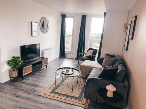 a living room with a couch and a tv at The Aspect, by Solace Stays in Cardiff