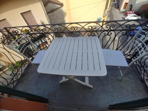 a white picnic table sitting on a balcony at Appartamento incantevole ad Armeno in Armeno