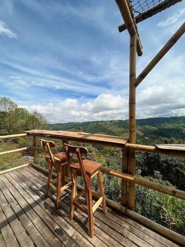 two chairs and a table on a wooden deck at HakunaMatata glamping Pumba in Salento