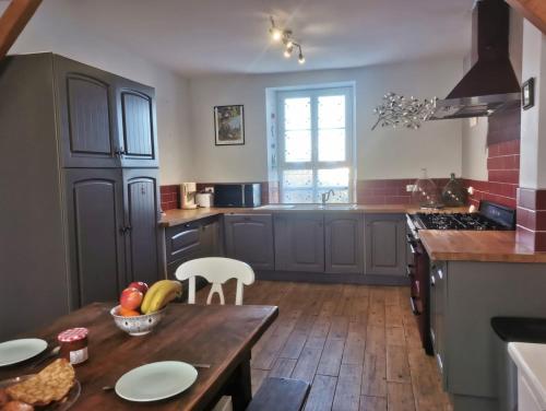 Il comprend une cuisine avec une table en bois et du parquet. dans l'établissement Ker Yaël – Maison familiale avec grand jardin à 5min de la plage Saint Jean du doigt, à Saint-Jean-du-Doigt
