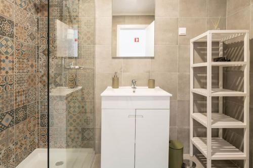 a bathroom with a white sink and a shower at Casa Oliveira - Sunny 2-Bed Retreat Steps from the Beach in Armação de Pêra