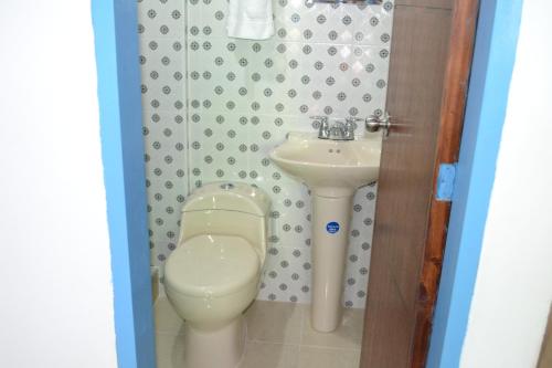 a bathroom with a toilet and a sink at Hostal Bosque de Niebla in Salento