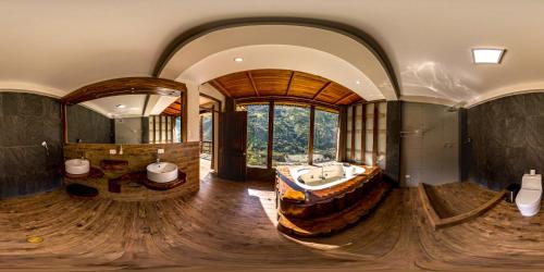 Vertikal lodge في سانتا تيريزا: حمام كبير مع حوض كبير ومرآة كبيرة