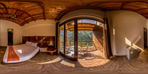een slaapkamer met een bed en een groot raam bij Vertikal lodge in Santa Teresa