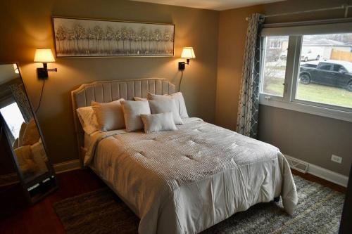 um quarto com uma cama com lençóis brancos e uma janela em Glen Ellyn Countryside Home em Glen Ellyn