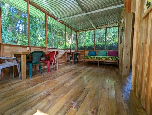 a room with chairs and a bench and windows at Arboura Eco Cabins in Uvita
