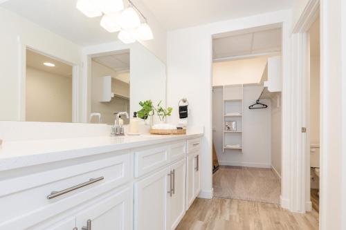 a white bathroom with a sink and a mirror at Brand New Garden City 3BR 2BA BOAT PARKING in Garden City