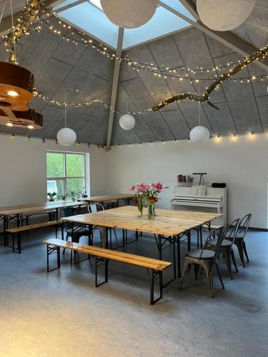 a large room with tables and chairs and lights at Room 17 - Hawkraft kulturhotel in Vestervig