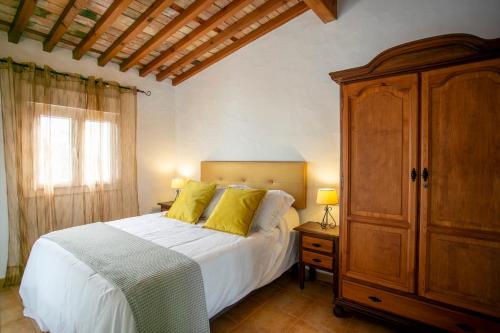 una camera con letto e armadio in legno di Estudio La Motilla a Facinas