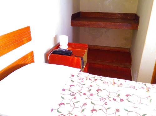 a bedroom with a bed with a white bedspread with flowers at Hostal La Rivera in Huanchaco