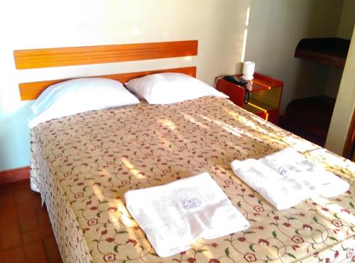 a bedroom with a bed with towels on it at Hostal La Rivera in Huanchaco