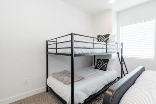 two bunk beds in a room with white walls at Bear Lake Fun Close to lake Electric Scooters in Garden City