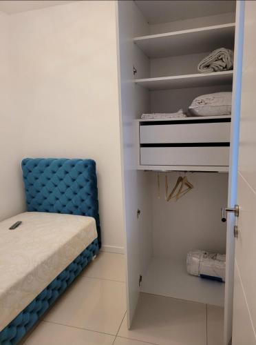 a room with a bed and a blue chair at Apartman Cookie Kolačić blizu aerodroma Nikola Tesla in Dobanovci