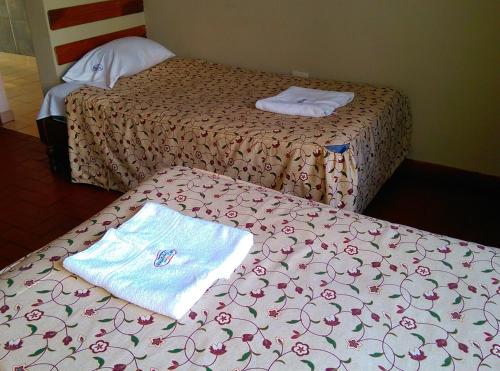 two beds with towels sitting on top of a bed at Hostal La Rivera in Huanchaco