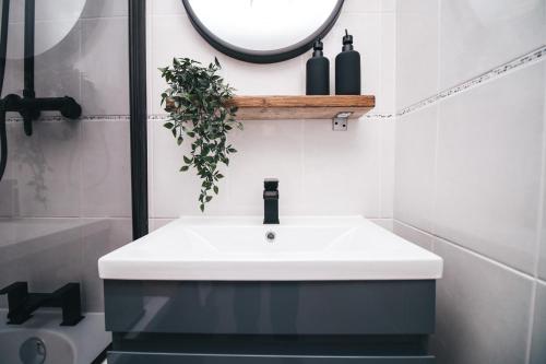 a bathroom with a white sink and a mirror at Commercial House, By Solace Stays in Newport