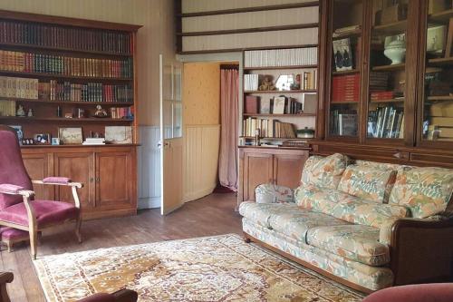 uma sala de estar com um sofá e algumas prateleiras de livros em La Volière em Champigny-sur-Veude