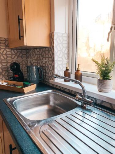 a stainless steel sink in a kitchen with a window at Grosvenor House by Solace Stays in Newport