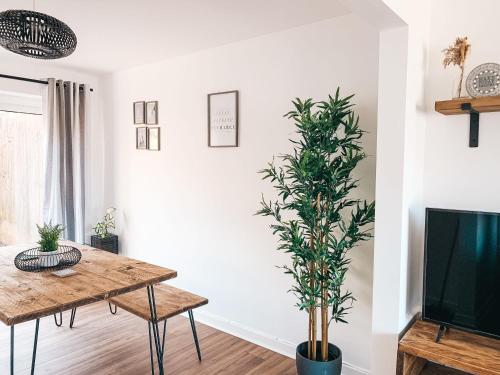 a living room with a table and a plant at Grosvenor House by Solace Stays in Newport