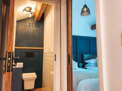 sypialnia z łóżkiem i drzwiami prowadzącymi do łazienki w obiekcie Falls Cottage by Solace Stays w mieście Merthyr Tydfil
