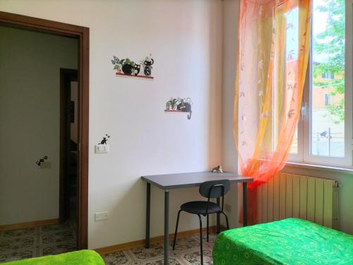 een kamer met een tafel, een raam en een kruk bij Casa dei MoMi in Piombino