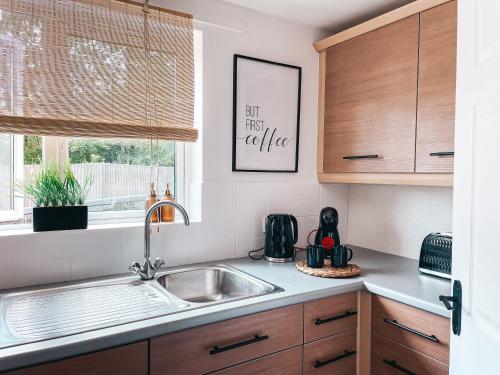 uma cozinha com um lavatório e uma janela em Hollybush Apartment, by Solace Stays em Newport