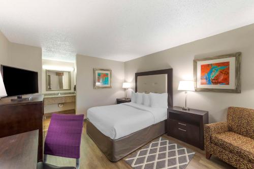 une chambre d'hôtel avec un lit et une chaise dans l'établissement Best Western Athens Inn, à Athens