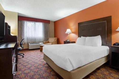 a hotel room with a large bed and a television at Best Western Plus The Inn at Sharon/Foxboro in Sharon