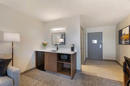 a hotel room with a desk with a tv and a mirror at Best Western Plus The Charles Hotel in St. Charles