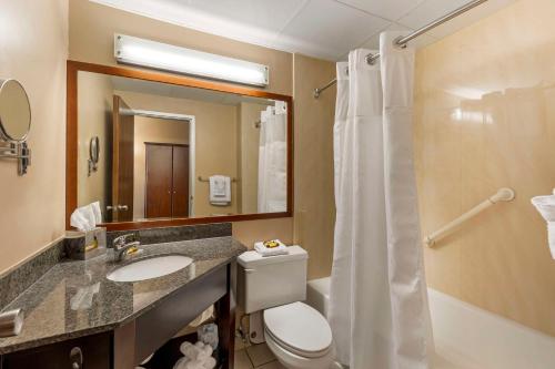 y baño con aseo, lavabo y ducha. en Best Western Plus The Charles Hotel, en St. Charles