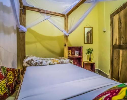 een bed in een kamer met gele muren bij The Secret Garden Hotel Moshi in Moshi