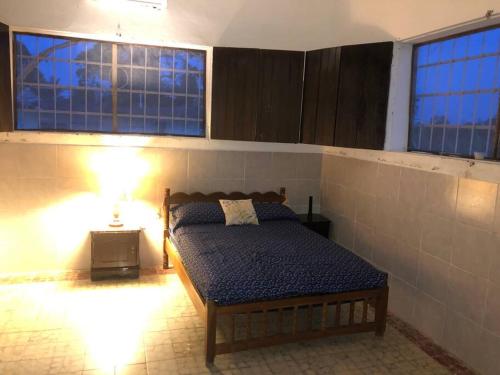 1 dormitorio con 1 cama en una habitación con ventanas en Casa de vacaciones rancho la chingada, en Tecolutla