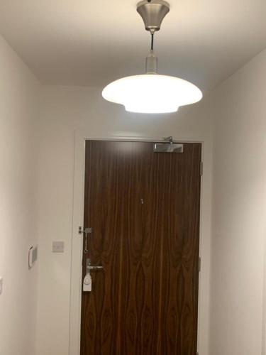 a large wooden door in a room with a light at Brand New Posh 1 Bed Lakeside Flat No parties No Events in West Thurrock