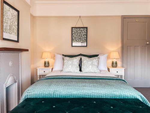 een slaapkamer met een groot bed met 2 nachtkastjes bij Ty Fry Gardens in Cardiff