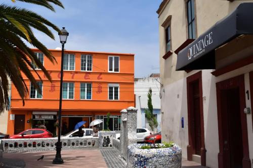 ein orangefarbenes Gebäude mit Straßenbeleuchtung davor in der Unterkunft Hotel RJ Querétaro in Querétaro