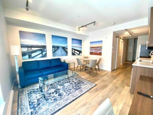 a living room with a blue couch and a table at Perfect Brand New Condo Downtown Sidney in Sidney