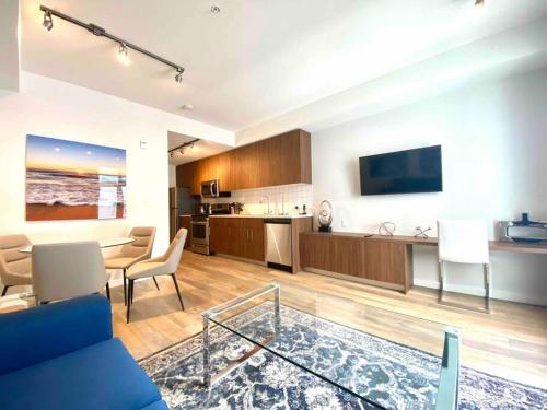 a living room with a blue couch and a kitchen at Perfect Brand New Condo Downtown Sidney in Sidney