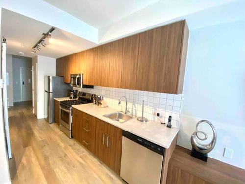 a large kitchen with a sink and a stove at Perfect Brand New Condo Downtown Sidney in Sidney