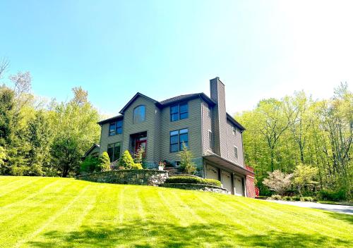 uma casa grande com um grande relvado em frente em Villa Verde B&B, bsm, Greenwood Lake, NY em Monroe