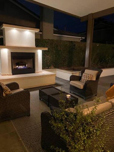 a living room with chairs and a fireplace at Private Heated Pool Oasis/Disney/Retro Arcade/Gym in Placentia