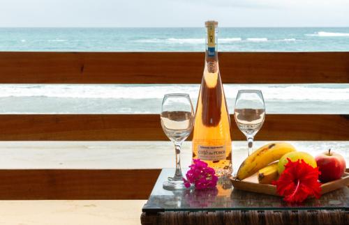 Una botella de vino y dos copas en una mesa. en Cormorant Beach House en Puerto Villamil